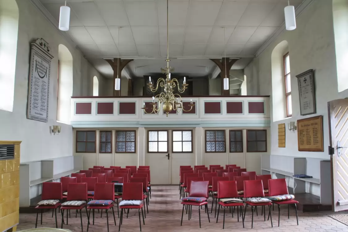 Innenraum der Dorfkirche Stechow mit Stuhlreihen, Empore und Leuchter